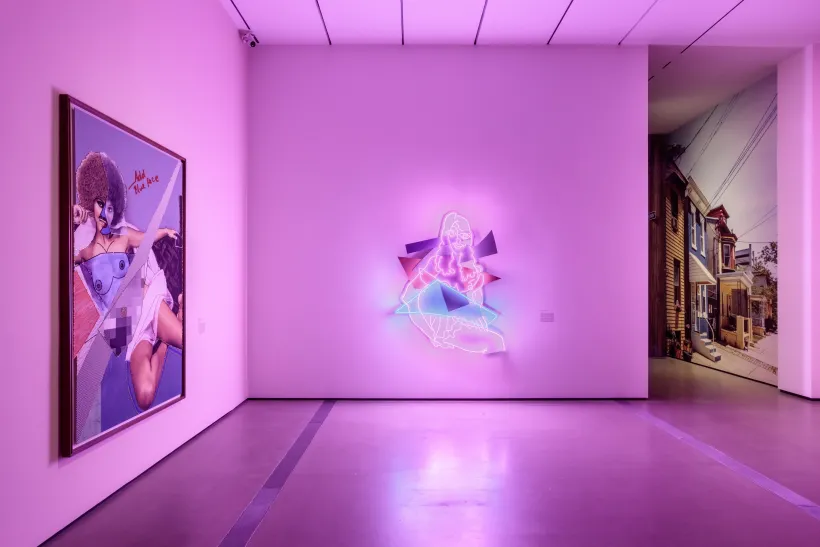 Gallery photo of The Broad's Mickalene Thomas exhibition featuring a pink and blue neon artwork and a collaged painting of a woman to its left