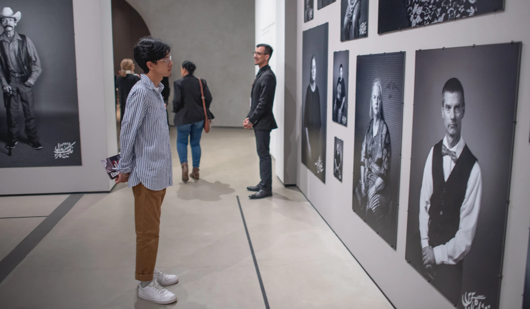 Photo of visitor looking at Shirin Neshat's work.