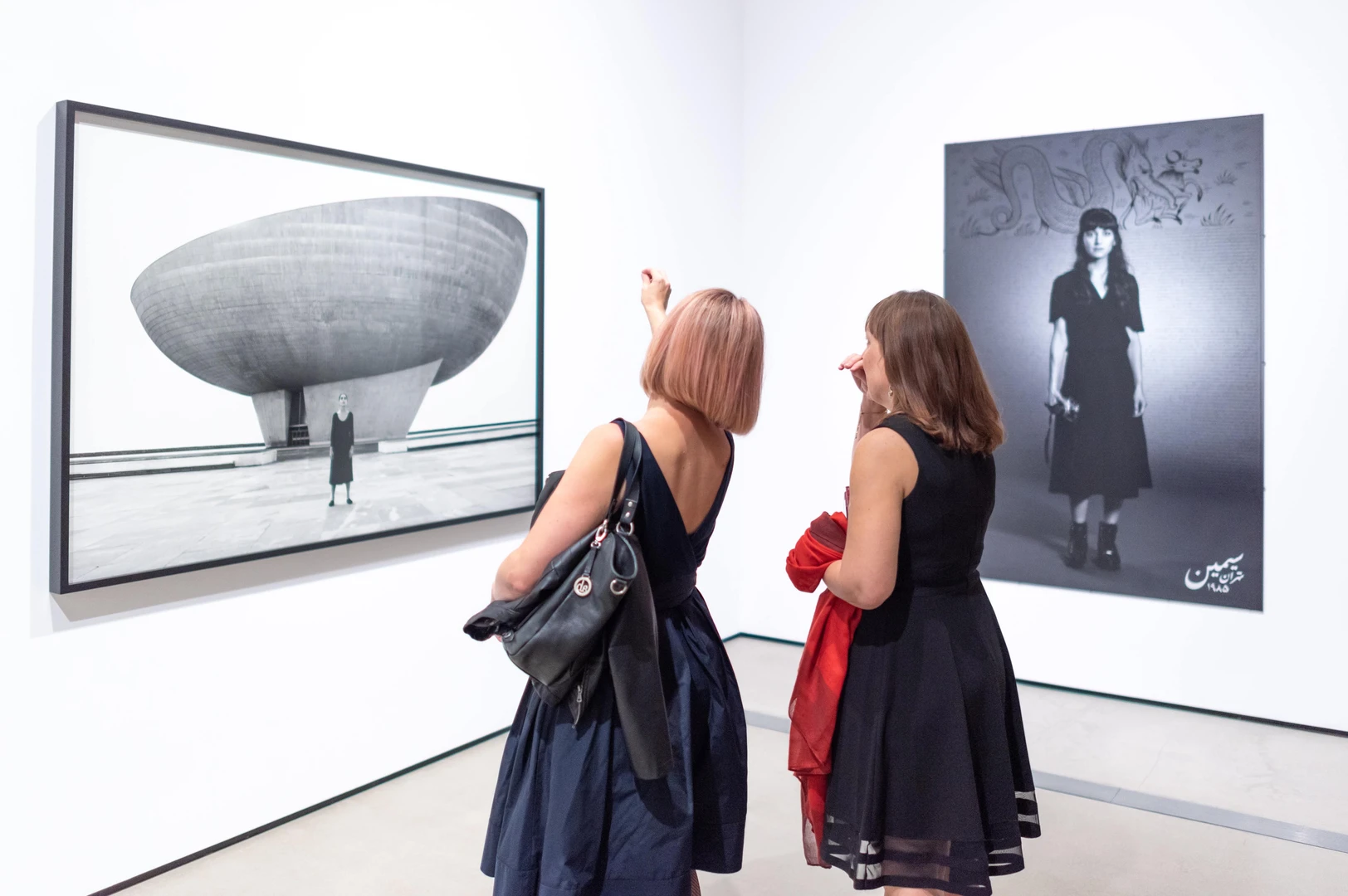 Photo of visitors looking at Shirin Neshat's work.